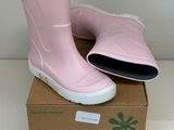 une paire de bottes de pluie roses posée sur une boîte en carton