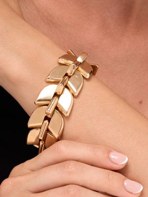 une femme portant un bracelet en or orné d'un motif de feuille