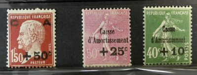 trois timbres de couleurs différentes exposés dans une vitrine