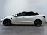 a white tesla model 3 parked in a white room