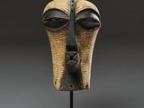 a close up of a sculpture of a face on a stand