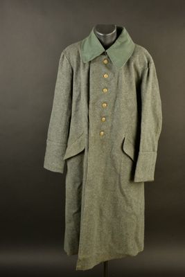 an image of a coat on a mannequin stand against a black background