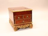 a small chest of drawers on a stand on a white surface