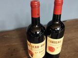 two bottles of wine sitting on a wooden table