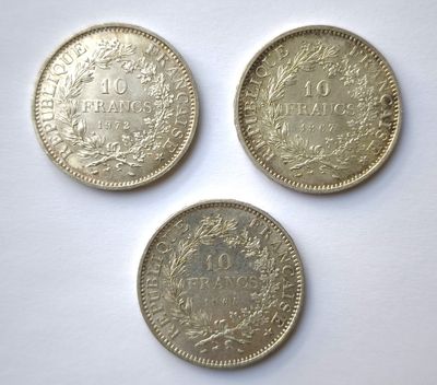 three different coins are shown on a white surface