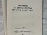 an open book sitting on top of a table next to a white sheet of paper