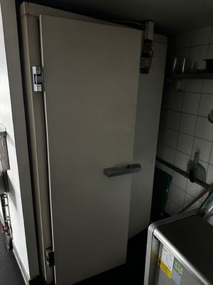 un réfrigérateur blanc dans une petite cuisine avec une fenêtre