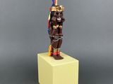 un gros plan sur une figurine représentant un homme avec une plume sur la tête