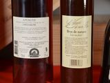 two bottles of wine sitting on a table next to each other