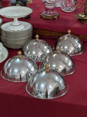 une table recouverte d'une nappe rouge, sur laquelle sont disposés des plats en argent