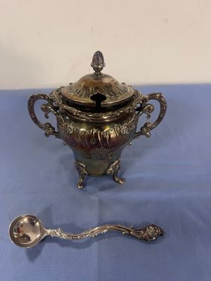 une assiette en argent avec une cuillère, posée sur une nappe bleue