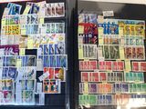 a refrigerator covered with stamps and postcards on the wall