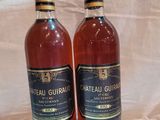 deux bouteilles de vin posées sur une table l'une à côté de l'autre