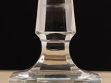 a clear glass candle holder sitting on a table