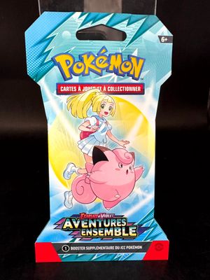un gros plan sur une boîte de cartes Pokémon représentant une fillette chevauchant un cochon