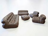 brown leather sofas and chairs are arranged on a white surface