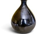 a black vase that is sitting on a white surface