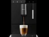 une machine à café sur laquelle est posée une tasse de café