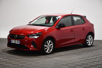 une voiture rouge garée dans une pièce au sol en damier