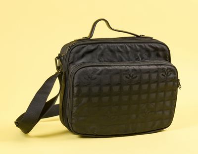 une image représentant un sac à bandoulière noir sur fond jaune