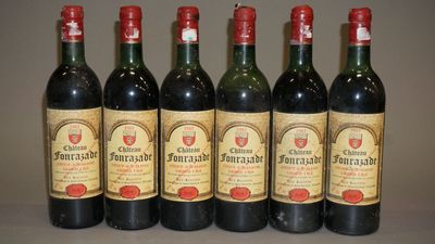 six bouteilles de vin sont alignées sur une table