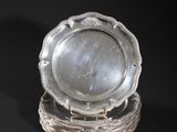 two silver plates on a stand on a black background