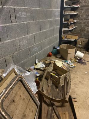 un tas de bric-à-brac dans une pièce, près d'un mur de briques
