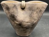 a large brown vase with a handle on it