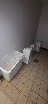 two toilets and a trash can in a bathroom