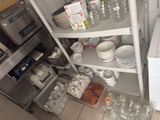 de nombreux plats et tasses sur les étagères de la cuisine
