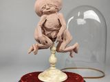 une sculpture représentant un bébé assis au sommet d'un dôme en verre