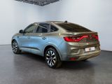 the rear end of a silver car in a white room