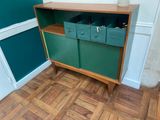 a green cabinet with drawers on it in the corner of a room