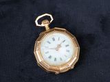 une montre de poche en or avec des chiffres romains