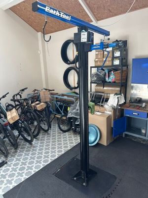 un élévateur à vélos dans un garage où se trouvent de nombreux vélos