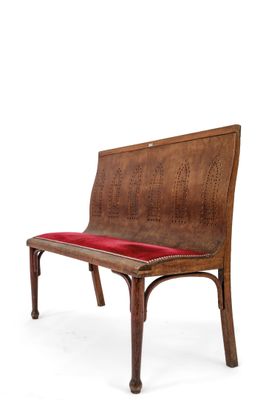 a wooden bench with a red cushion on it