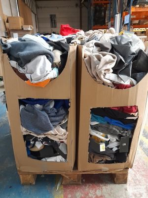two boxes with clothes on top of them in a warehouse