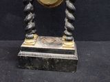 a clock that is sitting on a stand on a table