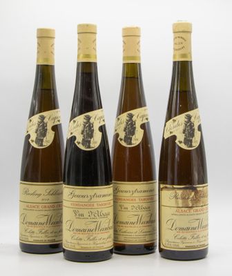 four bottles of wine are lined up on a white surface