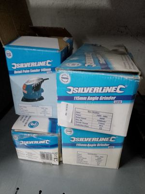 plusieurs cartons contenant des outils électriques posés sur une table