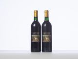 two bottles of wine sitting on top of a white table