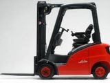 a red forklift truck that is sitting on a white surface
