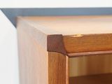 a close up of a wooden shelf with a black top