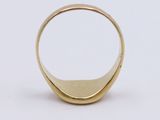 a close up of a gold ring on a white surface