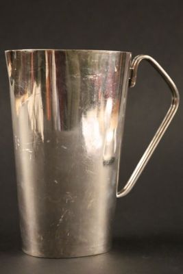 une vieille coupe en argent posée sur une table, devant un fond noir
