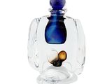 a glass jar with a blue lid and a snail inside of it