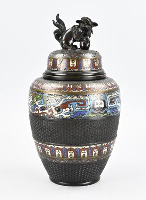 un vase noir surmonté d'un chien