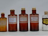 several bottles of medicine are lined up on a white surface