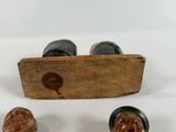 three small wooden figurines sitting on a white surface