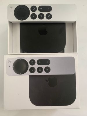 an apple tv sitting on top of a white box next to a remote